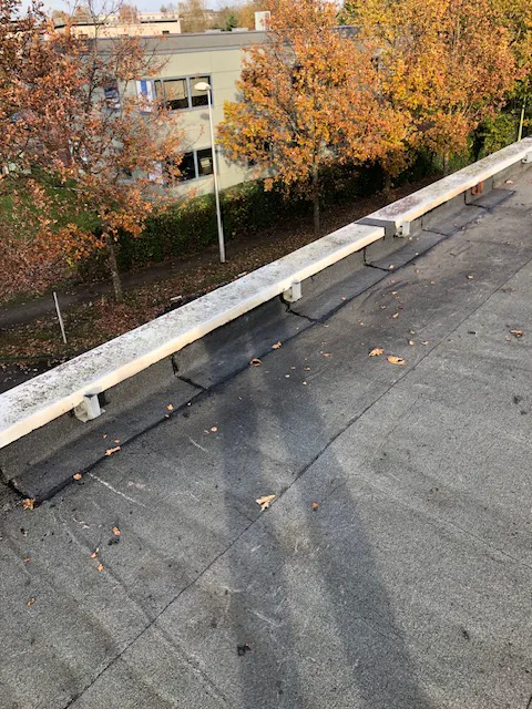 Trop-pleins traversant l'acrotère d'une toiture terrasse de bâtiment tertiaire