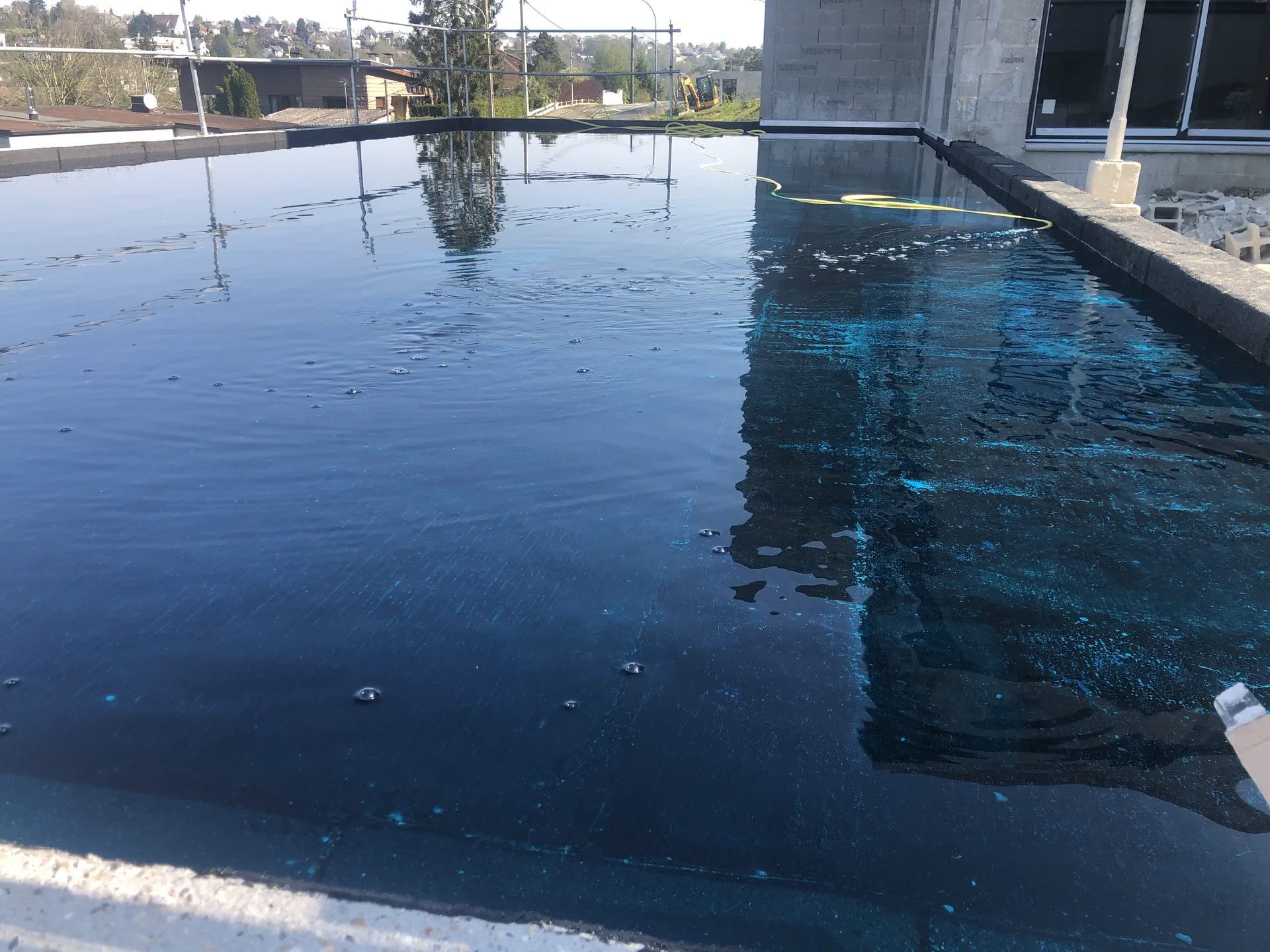 Mise en eau colorée d'une zone de toiture terrasse pour localiser une infiltration