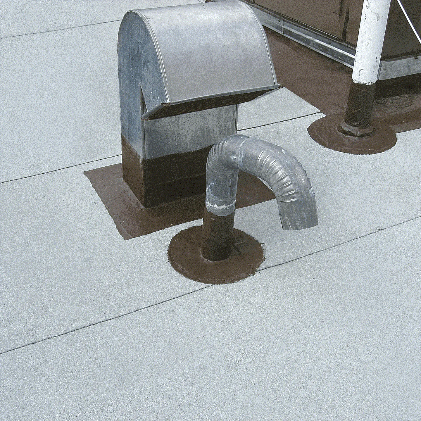 Étanchéité liquide fibrée appliquée au pied des pénétrations d'une toiture terrasse